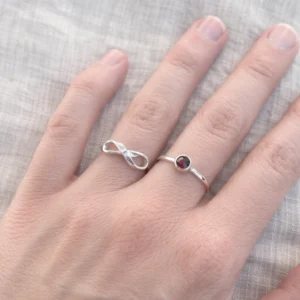 Zilveren infinity en granaat ringen aan hand